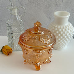 Vintage Jeannette marigold carnival glass candy dish with grape and leaf pattern, iridescent finish, and footed base
