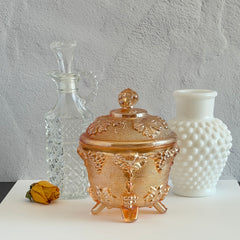 Vintage Jeannette marigold carnival glass candy dish with grape and leaf pattern, iridescent finish, and footed base