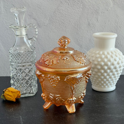Vintage Jeannette marigold carnival glass candy dish with grape and leaf pattern, iridescent finish, and footed base