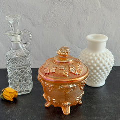 Vintage Jeannette marigold carnival glass candy dish with grape and leaf pattern, iridescent finish, and footed base