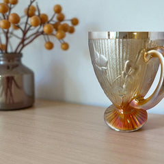 Vintage Jeannette marigold carnival glass pitcher with irises and herringbone pattern, ideal for sustainable home decor or serving drinks in eco-conscious style.