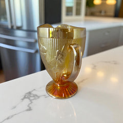 Vintage Jeannette marigold carnival glass pitcher with irises and herringbone pattern, ideal for sustainable home decor or serving drinks in eco-conscious style.