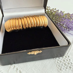 Vintage Joan Rivers gold‑tone link bracelet with rounded segments and elastic stretch design, shown from various angles to display details and condition.