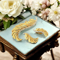 Vintage Jomaz feather brooch and earrings set from the early 1960s, featuring clear pave rhinestones set in silver-tone metal for the quill and textured gold-plated metal for the feather. Signed Jomaz on the back, in very good vintage condition with all original rhinestones present.