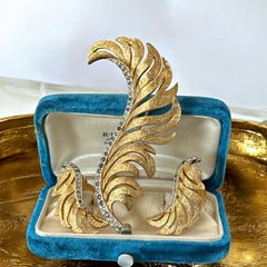 Vintage Jomaz feather brooch and earrings set from the early 1960s, featuring clear pave rhinestones set in silver-tone metal for the quill and textured gold-plated metal for the feather. Signed Jomaz on the back, in very good vintage condition with all original rhinestones present.