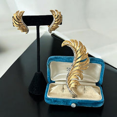 Vintage Jomaz feather brooch and earrings set from the early 1960s, featuring clear pave rhinestones set in silver-tone metal for the quill and textured gold-plated metal for the feather. Signed Jomaz on the back, in very good vintage condition with all original rhinestones present.