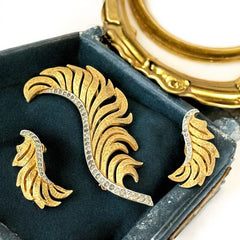 Vintage Jomaz feather brooch and earrings set from the early 1960s, featuring clear pave rhinestones set in silver-tone metal for the quill and textured gold-plated metal for the feather. Signed Jomaz on the back, in very good vintage condition with all original rhinestones present.