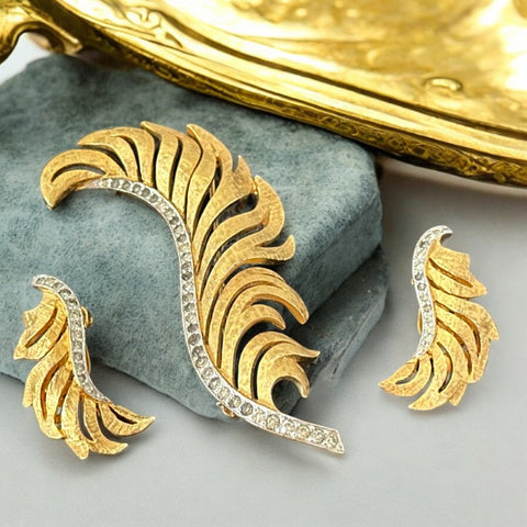 Vintage Jomaz feather brooch and earrings set from the early 1960s, featuring clear pave rhinestones set in silver-tone metal for the quill and textured gold-plated metal for the feather. Signed Jomaz on the back, in very good vintage condition with all original rhinestones present.