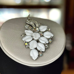 Vintage Jomaz floral spray brooch with molded milk glass leaves and aurora borealis rhinestones in silver tone setting, signed on reverse—1950s mid-century costume jewelry in excellent condition.