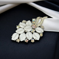 Vintage Jomaz floral spray brooch with molded milk glass leaves and aurora borealis rhinestones in silver tone setting, signed on reverse—1950s mid-century costume jewelry in excellent condition.
