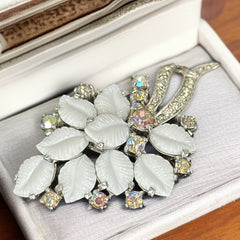 Vintage Jomaz floral spray brooch with molded milk glass leaves and aurora borealis rhinestones in silver tone setting, signed on reverse—1950s mid-century costume jewelry in excellent condition.
