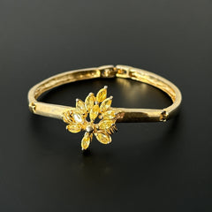 Vintage 1990s gold tone bracelet with curved links and a single jonquil marquise rhinestone flower centerpiece, elegant and gently worn.