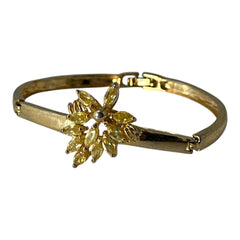Vintage 1990s gold tone bracelet with curved links and a single jonquil marquise rhinestone flower centerpiece, elegant and gently worn.