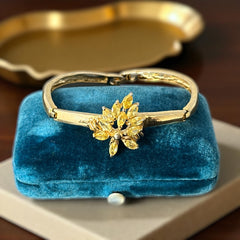 Vintage 1990s gold tone bracelet with curved links and a single jonquil marquise rhinestone flower centerpiece, elegant and gently worn.