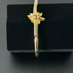 Vintage 1990s gold tone bracelet with curved links and a single jonquil marquise rhinestone flower centerpiece, elegant and gently worn.