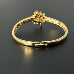 Vintage 1990s gold tone bracelet with curved links and a single jonquil marquise rhinestone flower centerpiece, elegant and gently worn.