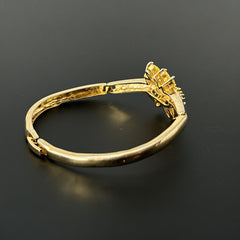Vintage 1990s gold tone bracelet with curved links and a single jonquil marquise rhinestone flower centerpiece, elegant and gently worn.