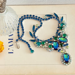 Vintage Juliana necklace with blue heliotrope oval stones and blue, green, and AB rhinestones in a silver‑tone setting.