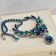 Vintage Juliana necklace with blue heliotrope oval stones and blue, green, and AB rhinestones in a silver‑tone setting.
