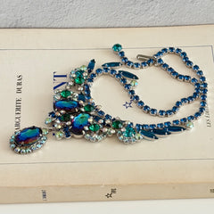 Vintage Juliana necklace with blue heliotrope oval stones and blue, green, and AB rhinestones in a silver‑tone setting.