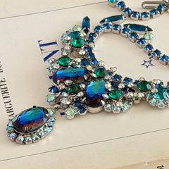 Vintage Juliana necklace with blue heliotrope oval stones and blue, green, and AB rhinestones in a silver‑tone setting.