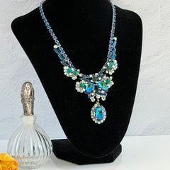 Vintage Juliana necklace with blue heliotrope oval stones and blue, green, and AB rhinestones in a silver‑tone setting.