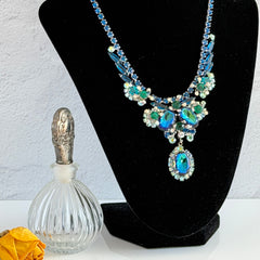Vintage Juliana necklace with blue heliotrope oval stones and blue, green, and AB rhinestones in a silver‑tone setting.