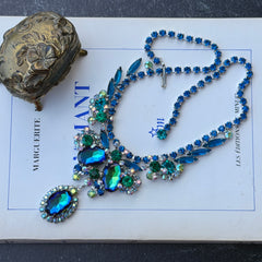 Vintage Juliana necklace with blue heliotrope oval stones and blue, green, and AB rhinestones in a silver‑tone setting.