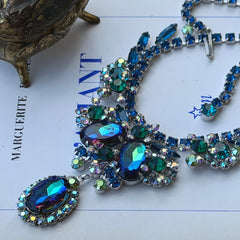 Vintage Juliana necklace with blue heliotrope oval stones and blue, green, and AB rhinestones in a silver‑tone setting.
