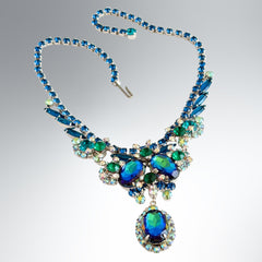 Vintage Juliana necklace with blue heliotrope oval stones and blue, green, and AB rhinestones in a silver‑tone setting.