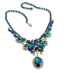 Vintage Juliana necklace with blue heliotrope oval stones and blue, green, and AB rhinestones in a silver‑tone setting.