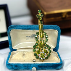Vintage Juliana violin brooch in gold tone metal with green and peridot rhinestones, featuring layered construction and floral accents; verified design #3151 from the 1960s, shown from front and back.