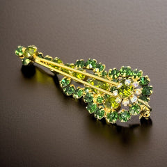 Vintage Juliana violin brooch in gold tone metal with green and peridot rhinestones, featuring layered construction and floral accents; verified design #3151 from the 1960s, shown from front and back.