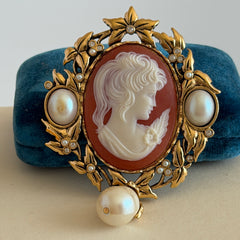 Vintage KJL for Avon gold tone cameo brooch pendant with resin cameo, faux pearls, clear rhinestones, and ornate detailing.