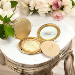 Vintage 1950s Kigu gold-tone powder compact with guilloché moiré lid, original puff, and mirror—collectible beauty accessory with timeless charm.
