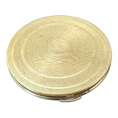 Vintage 1950s Kigu gold-tone powder compact with guilloché moiré lid, original puff, and mirror—collectible beauty accessory with timeless charm.
