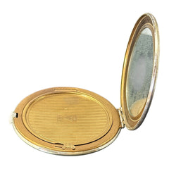 Vintage 1950s Kigu gold-tone powder compact with guilloché moiré lid, original puff, and mirror—collectible beauty accessory with timeless charm.
