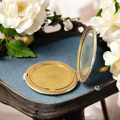 Vintage 1950s Kigu gold-tone powder compact with guilloché moiré lid, original puff, and mirror—collectible beauty accessory with timeless charm.
