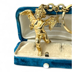 Gold-tone vintage Kirk’s Folly keychain featuring a winged cherub holding a small object, with a dangling star charm; detailed and symbolic design from the late 1980s–early 1990s.