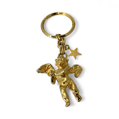 Gold-tone vintage Kirk’s Folly keychain featuring a winged cherub holding a small object, with a dangling star charm; detailed and symbolic design from the late 1980s–early 1990s.