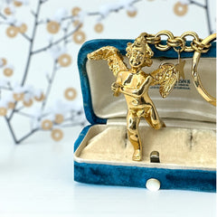 Gold-tone vintage Kirk’s Folly keychain featuring a winged cherub holding a small object, with a dangling star charm; detailed and symbolic design from the late 1980s–early 1990s.