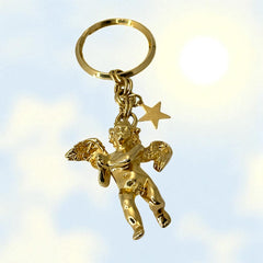 Gold-tone vintage Kirk’s Folly keychain featuring a winged cherub holding a small object, with a dangling star charm; detailed and symbolic design from the late 1980s–early 1990s.