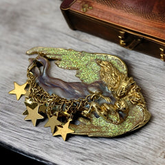 Vintage Kirk’s Folly guardian angel brooch with purple and cream enamel, iridescent sparkles, gold tone finish, signed on back, featuring angel holding baby with dangling star charms, excellent condition