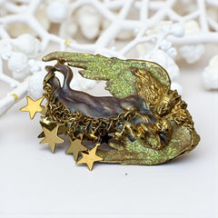 Vintage Kirk’s Folly guardian angel brooch with purple and cream enamel, iridescent sparkles, gold tone finish, signed on back, featuring angel holding baby with dangling star charms, excellent condition