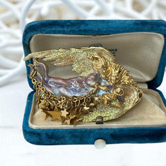 Vintage Kirk’s Folly guardian angel brooch with purple and cream enamel, iridescent sparkles, gold tone finish, signed on back, featuring angel holding baby with dangling star charms, excellent condition