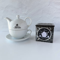 French black matelassé metal tea cube tin with silver accents and a pink teapot motif by Moldeo