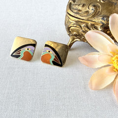 Vintage Laurel Burch “Tori Mon Bird of the Nile” square post earrings with orange, black, purple and green enamel bird motif on gold‑tone metal.