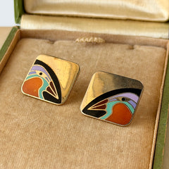 Vintage Laurel Burch “Tori Mon Bird of the Nile” square post earrings with orange, black, purple and green enamel bird motif on gold‑tone metal.