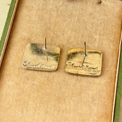 Vintage Laurel Burch “Tori Mon Bird of the Nile” square post earrings with orange, black, purple and green enamel bird motif on gold‑tone metal.