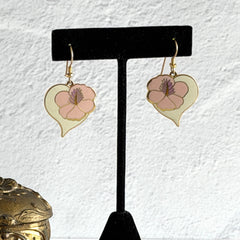 Vintage Laurel Burch Hibiscus Heart earrings with pink and white enamel flowers on gold‑tone heart dangles.